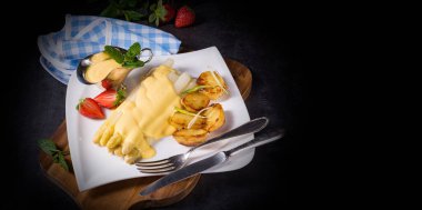 Kızarmış patates ve holandez soslu kuşkonmaz.