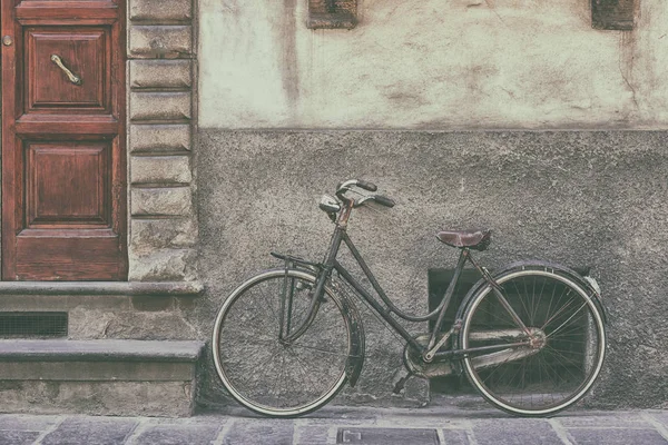 Oude fiets in de buurt van de muur — Stockfoto