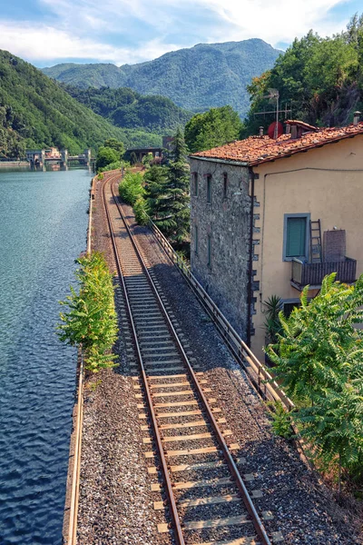 Železniční trati podél řeky v Itálii — Stock fotografie