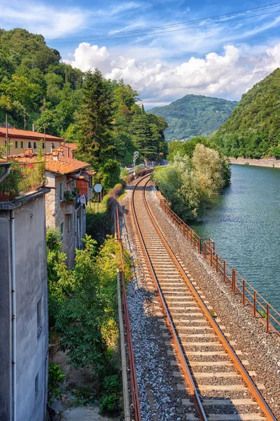 Železniční trati podél řeky v Itálii — Stock fotografie