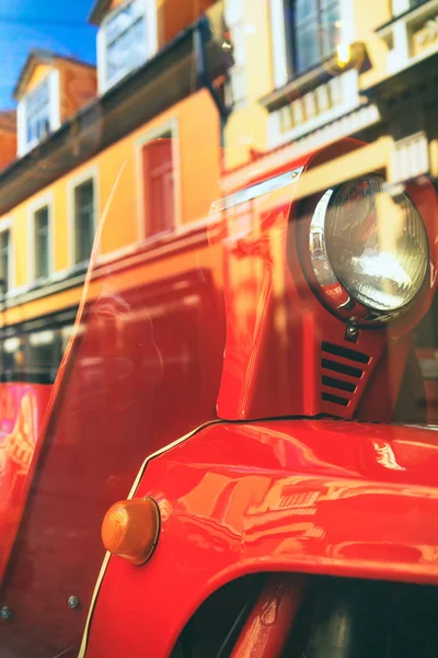 Red motor scooter in the city reflection