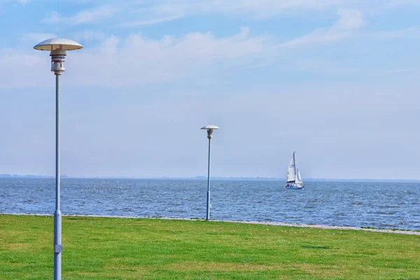 Um iate à vela vai ao longo da costa — Fotografia de Stock