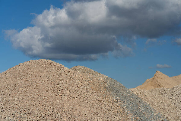 Mountains of sand and stone against a blue sky