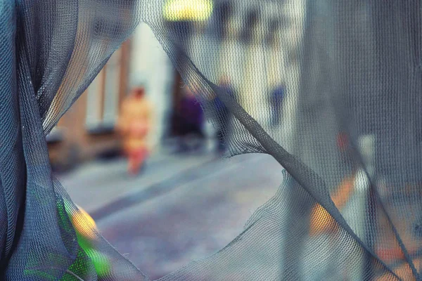 Calle en la ciudad a través de una malla rota —  Fotos de Stock