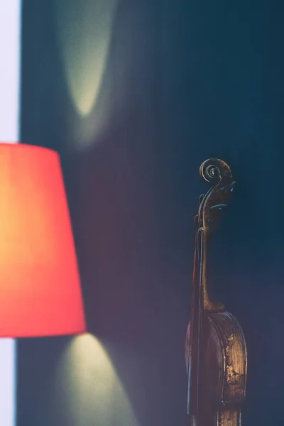 Geige an der Wand bei der roten Lampe — Stockfoto