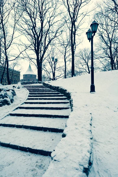 City park on the Bastion Hill in Riga in winter in the snow on the steps against the background of the Powder Medieval Tower. Riga, Latvia