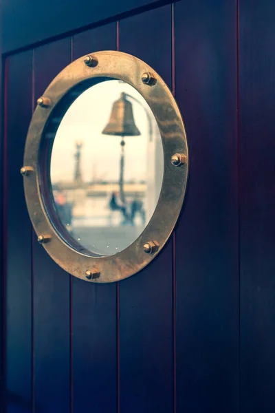 Porthole on a ship with a reflection of a market in glass — Stock Photo, Image
