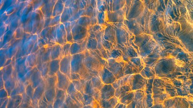 Güneşin parıltısı ve nehrin dibindeki dalgalar