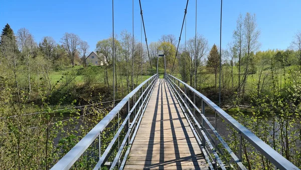 Suspension bridge over the river in spring