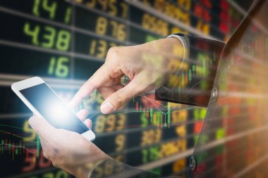 Borsa fiyatları arka planda kurulu ekran ile akıllı telefon kullanarak iş adamı