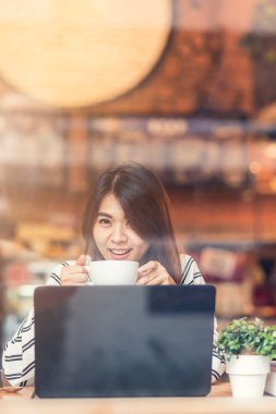  Asyalı kadın gülümseme kafede kahve içme sırasında