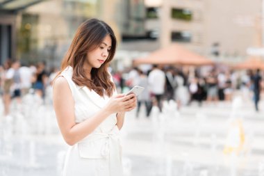 Genç güzel Asyalı kadın manifatura smartphone cep telefonu ile 