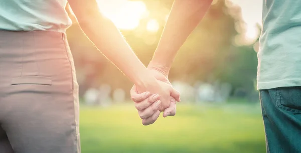 Pareja enamorada cogida de la mano en el parque —  Fotos de Stock