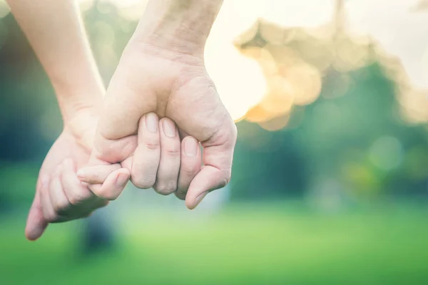 Casal apaixonado de mãos dadas no parque — Fotografia de Stock
