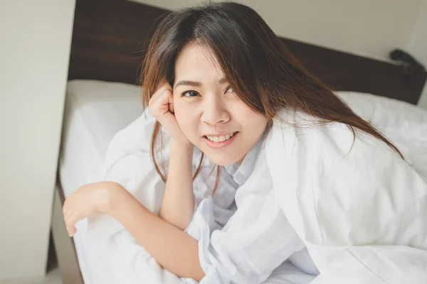 Ázsiai nő az ágyban reggel felébredni után — Stock Fotó