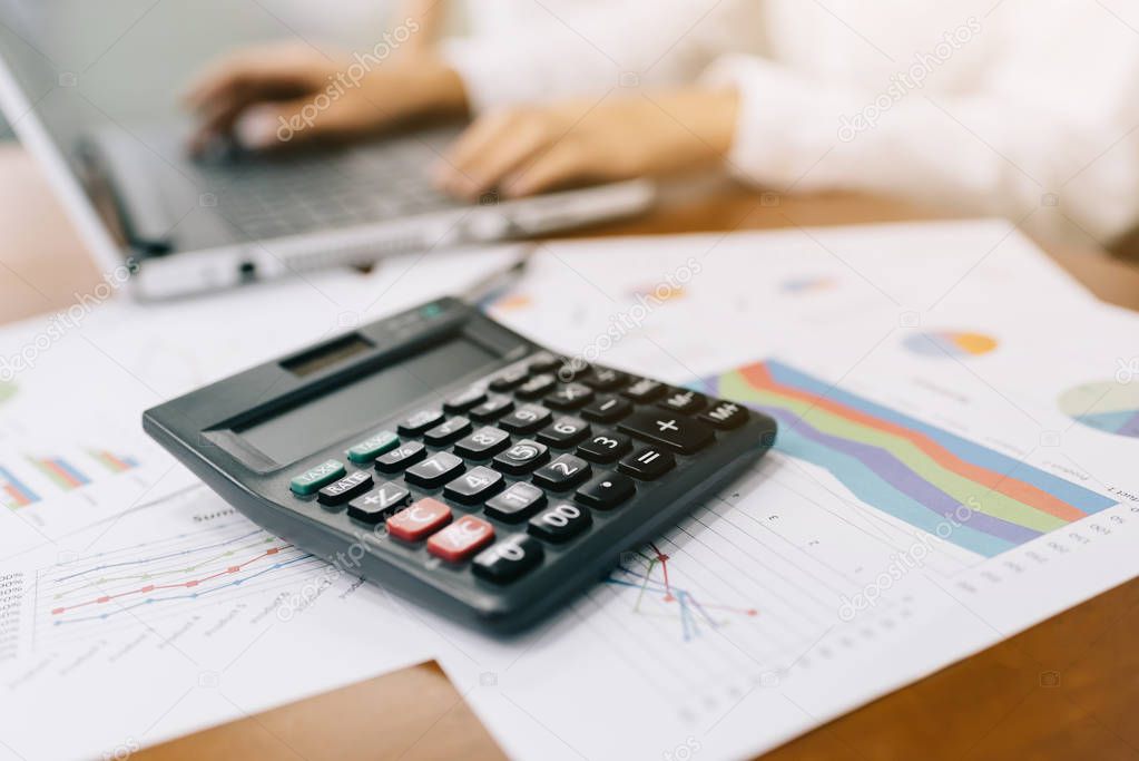 Calculator with businesswoman working