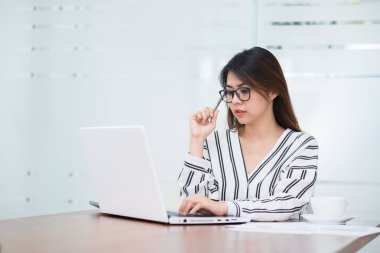 Laptop ile çalışırken düşünme genç Asyalı kadın