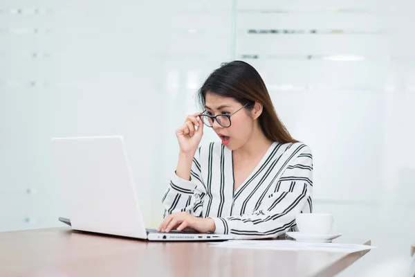 Joven mujer asiática sorprendida y emocionada mientras trabajaba con el ordenador portátil — Foto de Stock