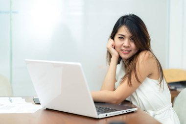  Dizüstü bilgisayar kullanırken Asyalı kadın gülümseme