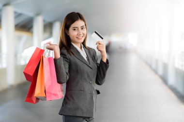 Renkli alışveriş çantası tutarken Asya işkadını gülümseme