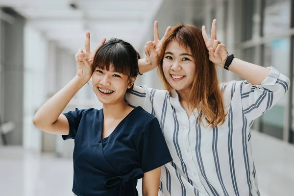 Счастливые азиатские девушки друзья показывая победный жест рукой — стоковое фото