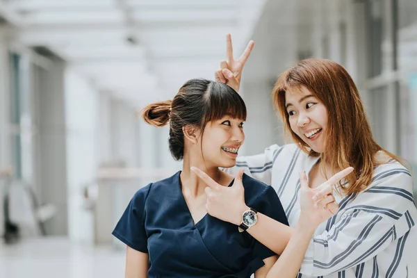 Две красивые счастливые азиатские девушки смеются и улыбаются вместе, веселясь — стоковое фото
