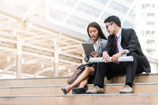 Asian businessman and woman discussing