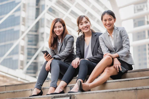 Três feliz mulher de negócios asiática colega sentado na escada — Fotografia de Stock