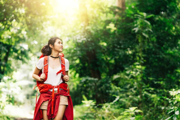 Mulher asiática viajante com mochila andando na floresta — Fotografia de Stock