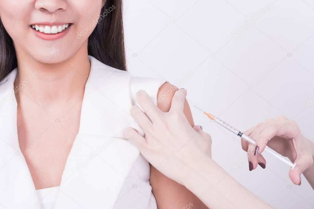 hand using syringe to make vaccine injection to patient 
