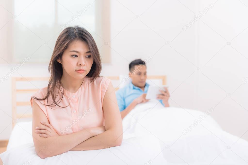 Unhappy young Asian couple having argument and quarrel while boyfriend ignored 