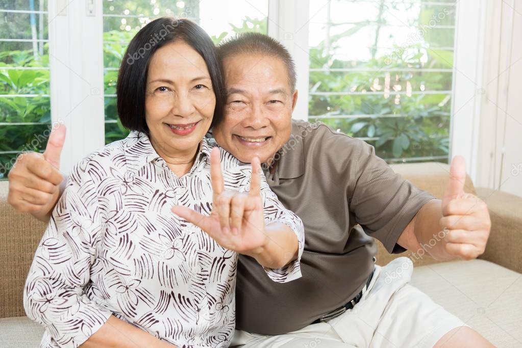 Happy senior Asian couple smiling at home