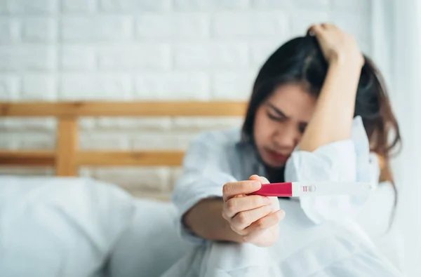 아시아 여자 잡고 긍정적인 결과와 임신 테스트 하는 동안 슬 프 고 겁을 느낄합니다 — 스톡 사진