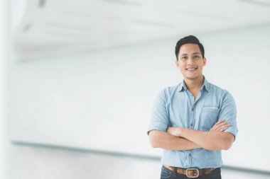 Asya adam kol ile gülümseyen modern ofis binası geçti