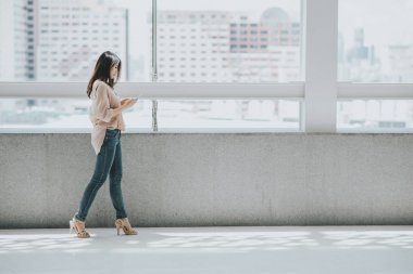 Asyalı kadın yürürken mesaj attığın için Smartphone kullanarak