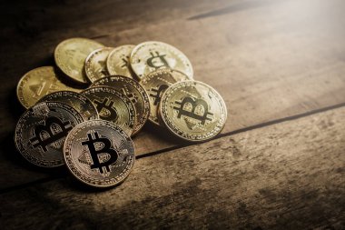 Ahşap masa zemin üzerine altın bitcoin yığını. Sanal cryptocurrency kavramı.