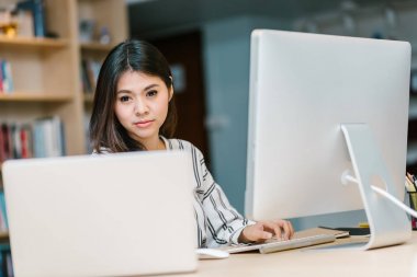 Dizüstü bilgisayar ve bilgisayar masada çalışma başlangıç iş veya öğrenci Asyalı kadın