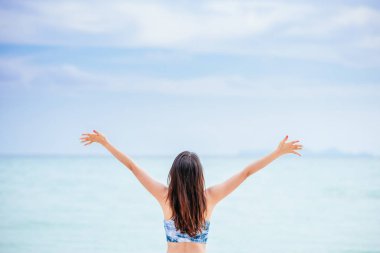 Bir gün sahilde mutlu hoş genç kadının arkadan görünüm