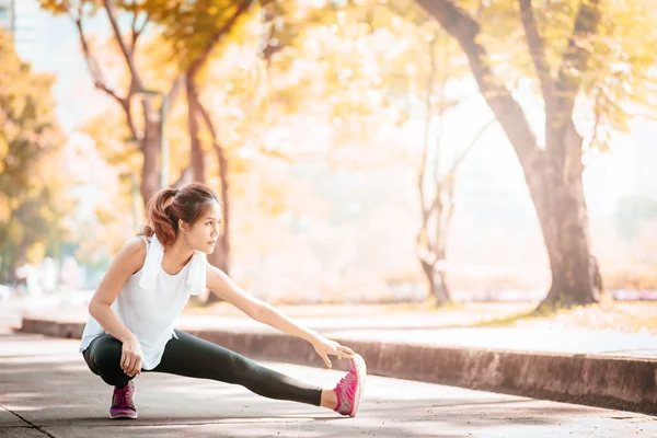 年轻的亚洲妇女做一些热身运动和拉伸之前 早晨在公园跑步与阳光 — 图库照片