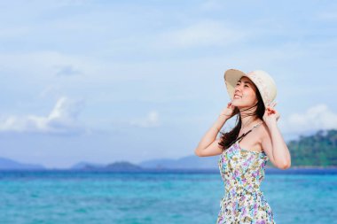 Bir gün ile plajda mutlu keyifli güzel genç Asyalı kadının arka plan mavi gökyüzünde temizleyin