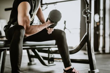 Fitness adamı halterle egzersiz yapıyor.