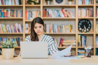 Dizüstü bilgisayar ve belge çalışma tablosu üzerinde çalışma güzel Asyalı kadın