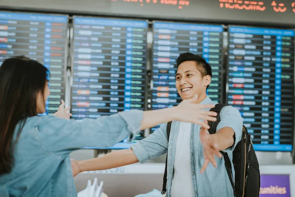 Sıcak hoş geldiniz sevgilisi için dönüş o sonra bir havaalanında yurtdışından sarılma vererek mutlu Asyalı kadın 
