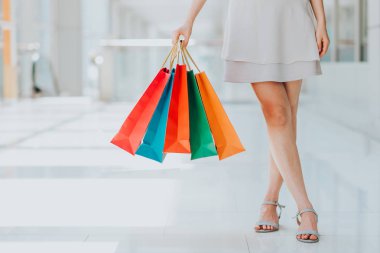 Kadın taşıyan renkli alışveriş torbaları