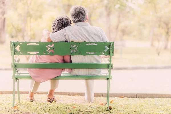 Parktaki bankta oturan yaşlı çift. 