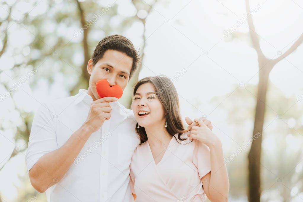 Happy smiling Asian couple in love having a good time in the morning  at park