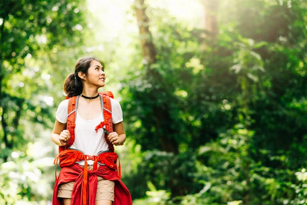 Жінка мандрівник з рюкзаком, що йде в лісі — стокове фото