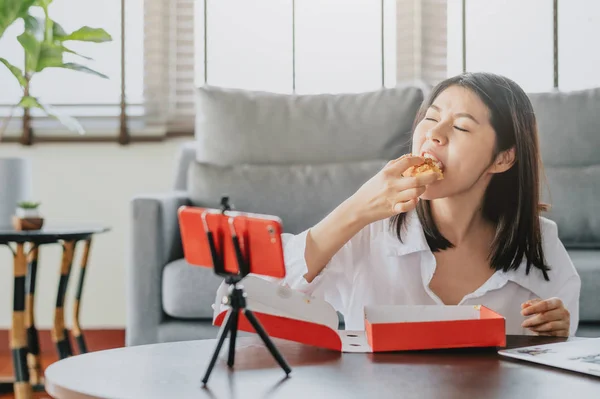 Woman food blogger eating pizza while creating new  content vide