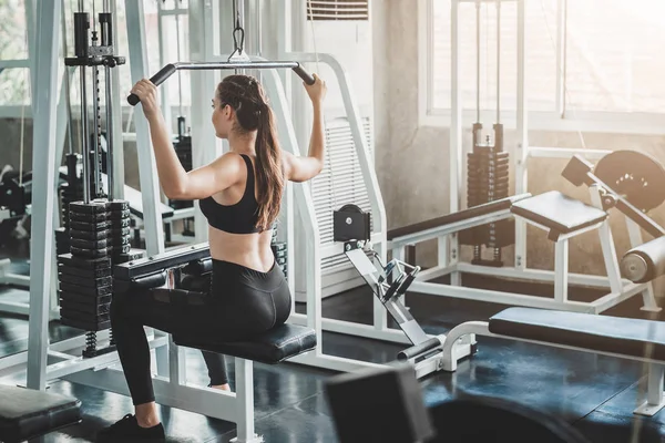 Woman doing lat pull pull down exercise in fitness gym — Stock Photo, Image