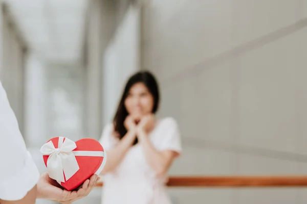 Férfi gazdaság piros szív alakú ajándék doboz ajándék meglepetés nő — Stock Fotó